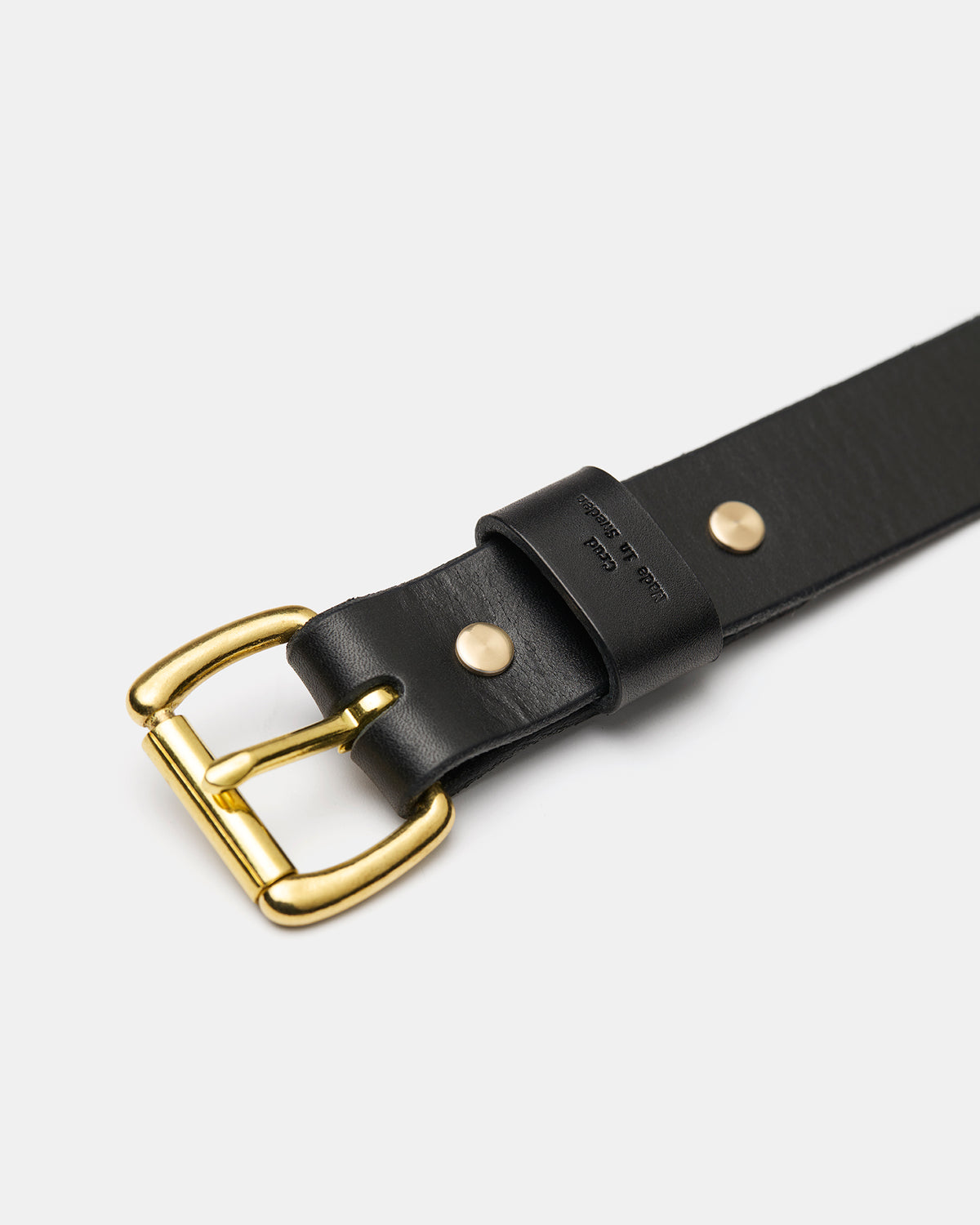 Close-up of solid brass roller buckle on black leather belt