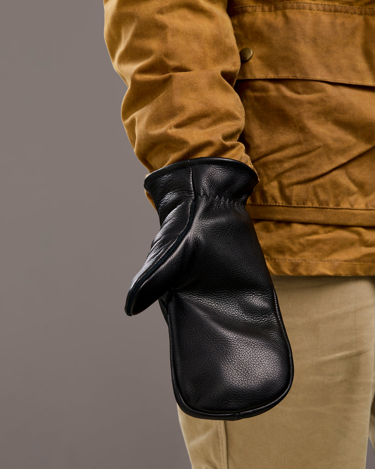 Mitsuhiko black mittens shown worn on hand palmside