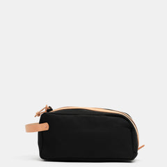Black waxed canvas toiletry bag with natural vegetable-tanned leather handle and trim by Crud