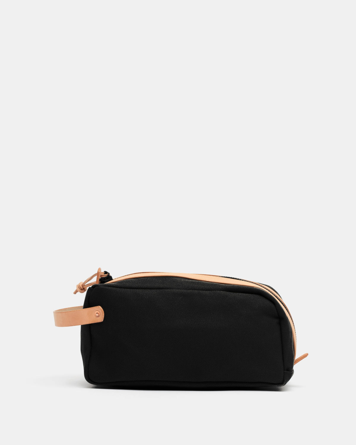 Black waxed canvas toiletry bag with natural vegetable-tanned leather handle and trim by Crud