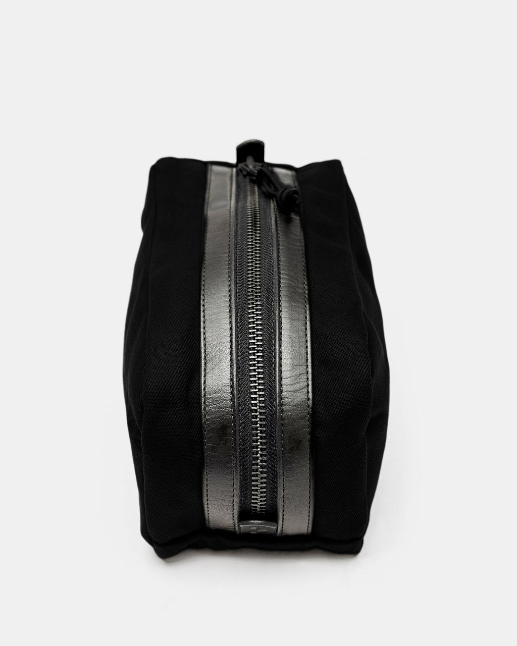 Top view of black toiletry bag with zipper and black leather trim